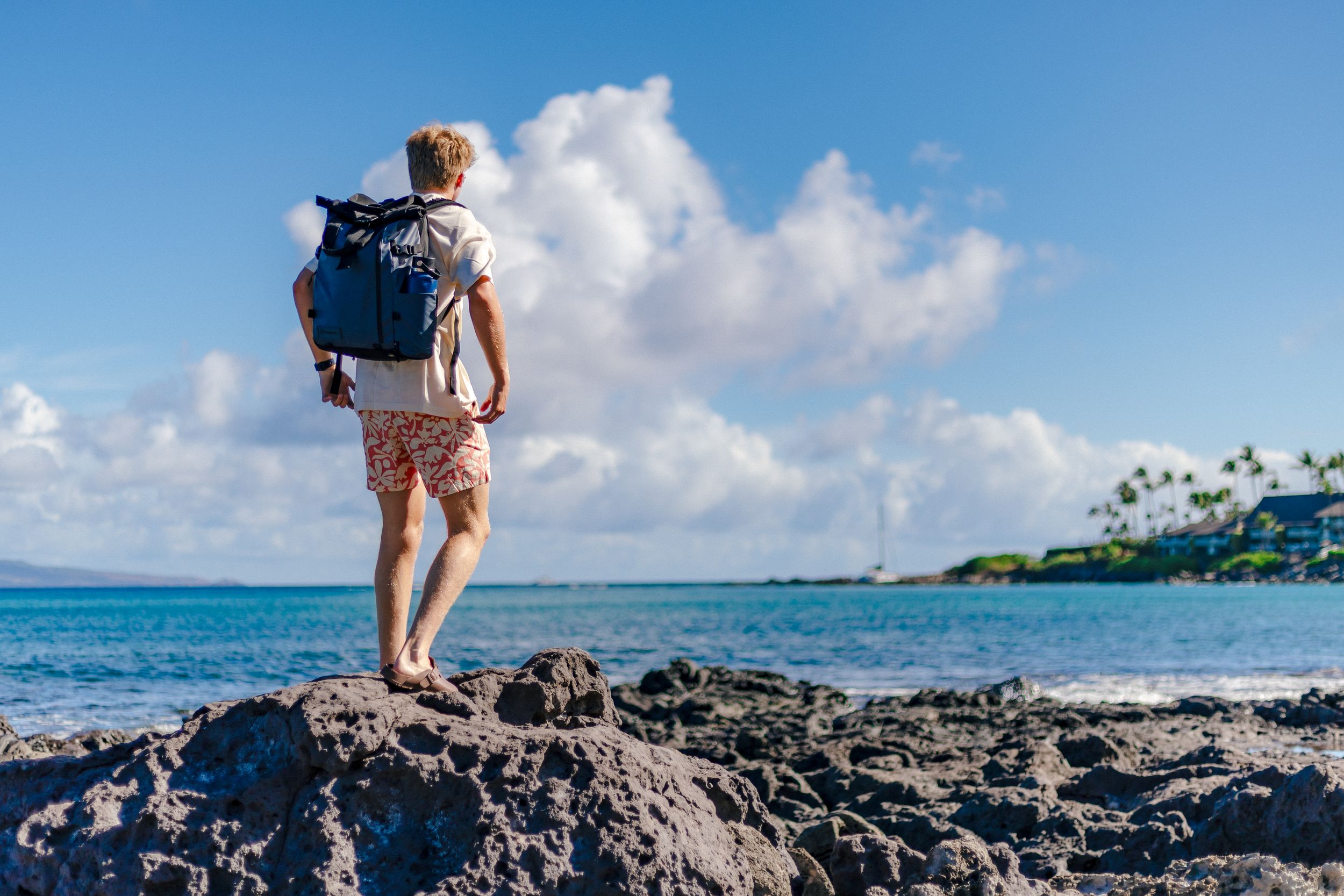 Kaiden Mertzel on a rocky shoreline in Hawaii